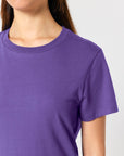 A person wearing a Stanley/Stella STTW172 Stella Muser The Iconic Women's T-Shirt made of organic cotton. Only the upper portion of the torso and part of the neck and chin are visible.