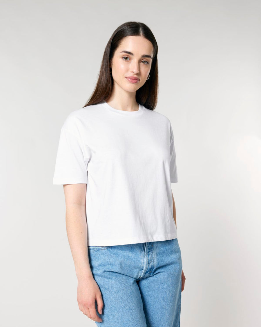 Woman wearing a STTW175 Stella Nova Womens Boxy T-Shirt and blue jeans standing against a light background.